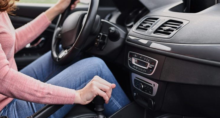 Woman driving car. Female hand change speed on manual gearbox